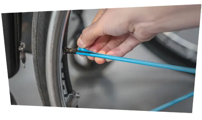 Main installant un Seksi Spoke coloré sur le rayon d’une roue de fauteuil roulant